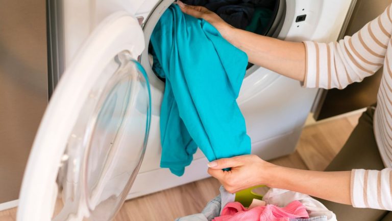 La lavatrice puzza? La poltiglia nascosta che contamina ogni tuo lavaggio Una donna che svuota il cestello della lavatrice (fonte: Freepik)